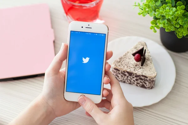 Frau mit iphone6s roségold mit social service twitter — Stockfoto