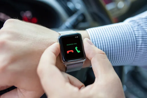 Hombre con reloj inteligente y llamada entrante en el coche —  Fotos de Stock