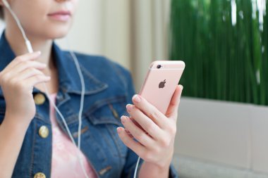 Kadın el iphone6s Rose Altın tutarak kulaklıklar ile