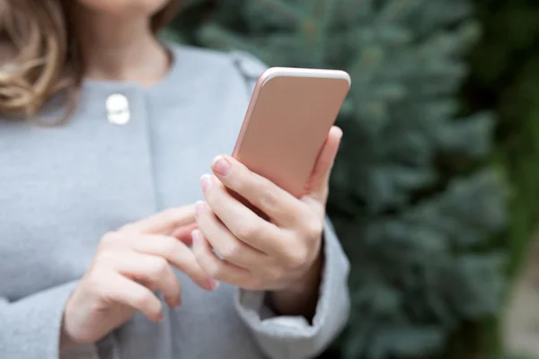 Kobieta na ulicy przytrzymanie różowy telefon — Zdjęcie stockowe