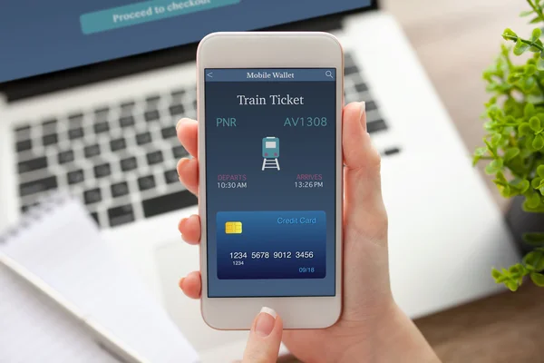 Женский телефон с билетом на поезд и ноутбуком — стоковое фото