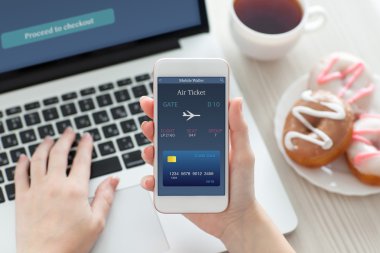 online uçak bileti ve dizüstü bilgisayar ile telefon tutan eller