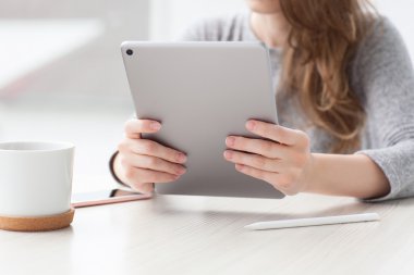 Yaz kafede oturan kadın tablet bilgisayar tutan çay içer