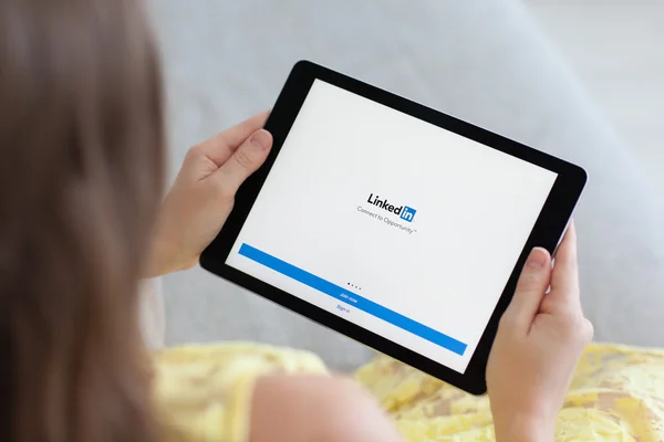 Linkedin の社会的ネットワークとプロのスペース グレー ipad を保持している女性 — ストック写真