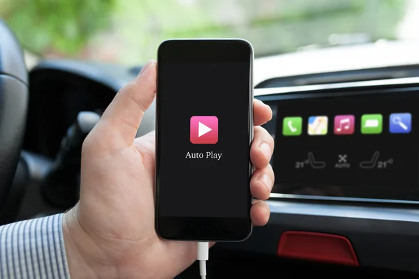 Man hand in car holding phone with app Auto Play — Stock Photo, Image