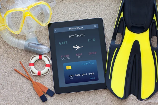 Tableta con ordenador con billete de avión en línea acostado en la arena — Foto de Stock