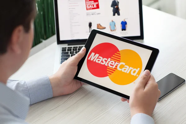 Hombre sosteniendo el servicio del sistema de pago iPad Pro MasterCard en pantalla — Foto de Stock