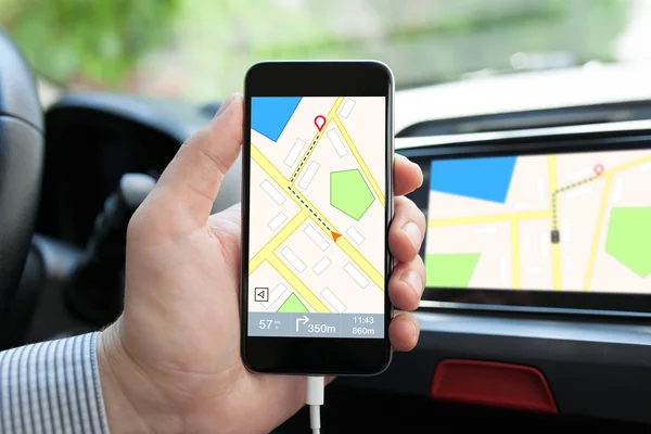 Ręką człowieka w samochodem trzymając telefon z Nawigacja Mapa — Zdjęcie stockowe