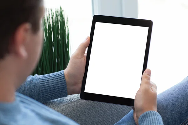 Man zit op de Bank houden van tablet pc met geïsoleerde scherm — Stockfoto