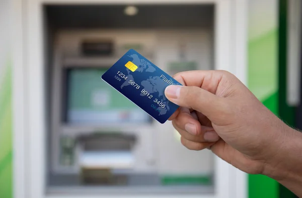 Männliche Hand Hält Plastikkreditkarte Auf Dem Hintergrund Des Geldautomaten — Stockfoto