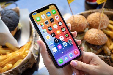 Alanya, Türkiye - 13 Ekim 2020: Ekranda IOS 14 ekranlı iPhone 11 ile el ele tutuşan kadın. iPhone 11 Apple tarafından oluşturuldu ve geliştirildi..