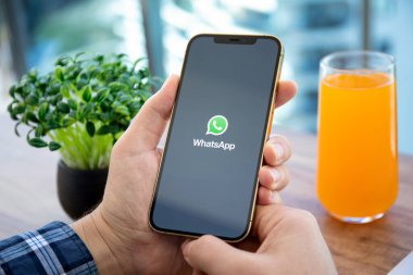 Alanya, Türkiye - 18 Aralık 2020: Ekranda haberci WhatsApp ile iPhone 12 Pro Max Gold ile el ele tutuşan adam.