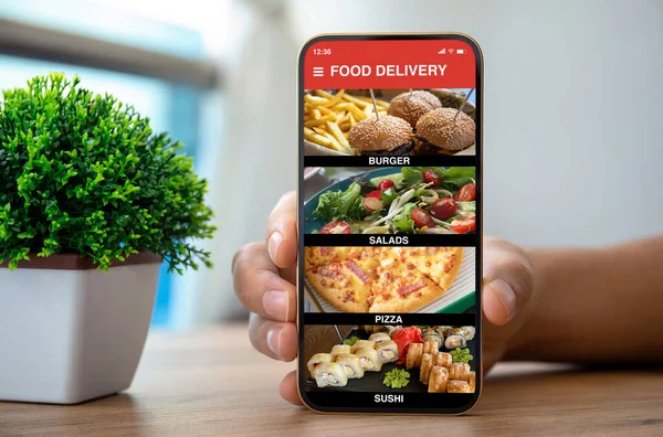 Mãos Masculinas Segurando Telefone Com Aplicativo Entrega Alimentos Sobre Mesa — Fotografia de Stock