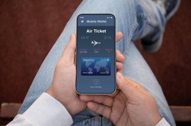 Havaalanında uçak bileti başvurusu yapan erkeklerin elleri ekranda.