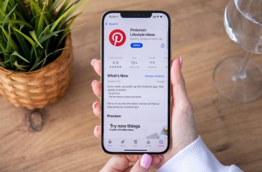 Alanya, Türkiye - 25 Şubat 2021: Ekranda Pinterest uygulamalı iPhone 12 Pro Max Gold ile el ele tutuşan kadın. iPhone Apple tarafından oluşturuldu ve geliştirildi..