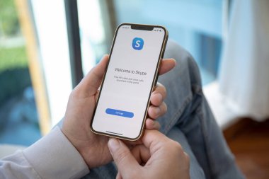 Alanya, Türkiye - 6 Aralık 2020: Skype uygulamasını arayarak iPhone 12 Pro Max Gold ile el ele tutuşmak