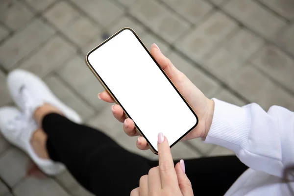 female hands holding golden phone with isolated screen on the street