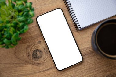 Ofisteki ahşap masadaki izole ekranlı altın telefon.