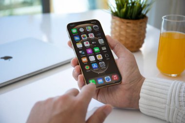 Alanya, Türkiye - 30 Mart 2021: İnsan eli iPhone 12 Pro Max Gold ile ana ekran IOS 14 ekranda.