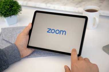 Alanya, Türkiye - 11 Mayıs 2021: İnsan elleri Zoom Video İletişim uygulamasını arayarak Apple iPad Air Space Gray 'i tutuyor.