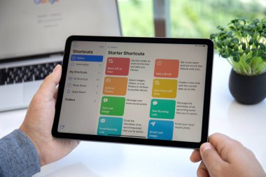 Alanya, Türkiye - 11 Mayıs 2021: İnsan eli iPad Air Space Gray ile ana ekran Kısayol uygulaması. iPad Air Apple tarafından yaratıldı ve geliştirildi.