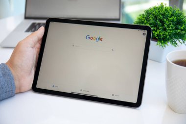 Alanya, Türkiye - 11 Mayıs 2021: iPad Air Space Gray 'i tutan adam ve sosyal ağ hizmeti Google ekranda.