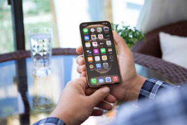 Alanya, Türkiye - 9 Mayıs 2021: İnsan eli iPhone 12 Pro Max Gold ile ana ekran IOS 14 ekranında