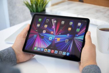 Alanya, Türkiye - 11 Mayıs 2021: İnsan eli iPad Air IOS 14 ile ana ekranda donanım. iPad Apple tarafından yaratıldı ve geliştirildi..