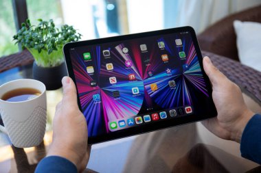 Alanya, Türkiye - 12 Mayıs 2021: İnsan eli iPad Air IOS 14 ile ana ekranda donanım. iPad Apple tarafından yaratıldı ve geliştirildi..