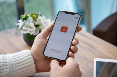 Alanya, Türkiye - 31 Mart 2021: Ekranda İnternet alışveriş servisi Aliexpress ile iPhone 12 Pro Max Gold 'u tutan erkekler