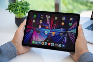 Alanya, Türkiye - 11 Mayıs 2021: İnsan eli iPad Air IOS 14 ile ana ekranda donanım. iPad Apple tarafından yaratıldı ve geliştirildi..