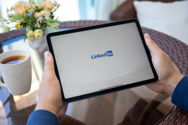 Alanya, Türkiye - 12 Mayıs 2021: Sosyal ağ servisi LinkedIn ile birlikte iPad Air Space Gray 'i tutan adam ekranda. iPad Air Apple tarafından yaratıldı ve geliştirildi.