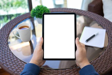 Kafedeki masanın izole ekran arka planına sahip bilgisayar tabletini tutan erkek elleri 