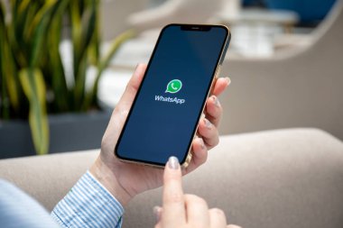 Alanya, Türkiye - 7 Haziran 2021: Kadın eli iPhone 12 Pro Max Gold ve sosyal ağ hizmetleri kuryesi WhatsApp ekranda.