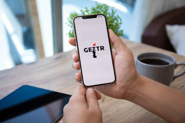 Alanya, Türkiye - 7 Temmuz 2021: İnsan eli iPhone 12 Pro Max Gold ve sosyal ağ hizmetleri kuryesi Gettr ekranda.