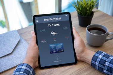 erkek eller ekranda uçak bileti başvuru havayolu ile bilgisayar tableti tutuyor 