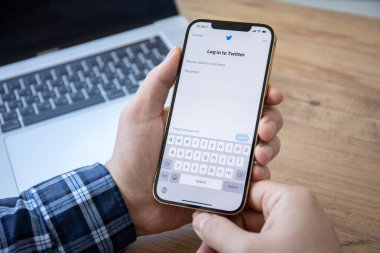 Alanya, Türkiye - 7 Ocak 2021: İnsan eli iPhone 12 Pro Max Gold ve sosyal ağ hizmetleri Twitter ekranda.