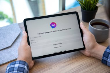 Alanya, Türkiye - 14 Mayıs 2021: İnsan eli iPad Air Space Gray ile sosyal ağ hizmetleri kuryesi Facebook ekranda.