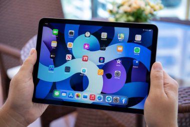 Alanya, Türkiye - 15 Haziran 2021: İnsan eli iPad Air IOS 14 ile ana ekranda donanım. iPad Apple tarafından yaratıldı ve geliştirildi..