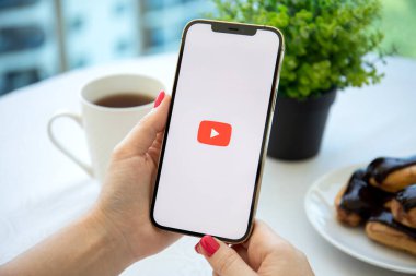 Alanya, Türkiye - 3 Ağustos 2021: Apple iPhone 12 Pro Max Gold uygulaması ile el ele tutuşan kadın ekranda medya ve video sunuyor.