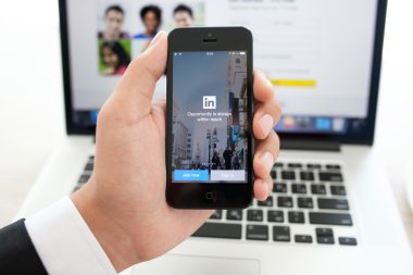 işadamı iPhone app LinkedIn üstünde belgili tanımlık perde ile tutarak bir