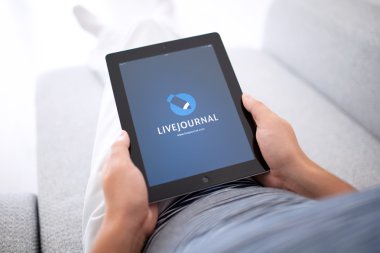 adam kanepede yatan ve ipad app livejournal ile tutarak