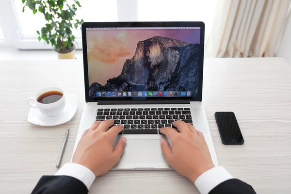 Üzletember ül a macbook pro retina osx yosemite — Stock Fotó