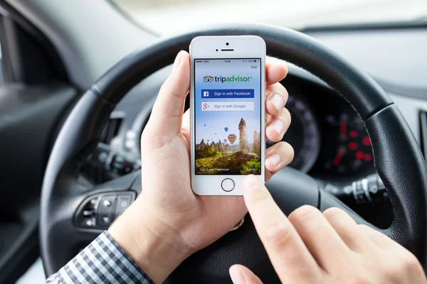 IPhone 5S app TripAdvisor in hands of the driver car — Stock Photo, Image