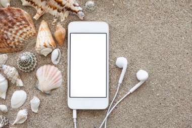 telefon ile izole ekran ve kum üzerinde kulaklık