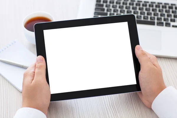 Tablet met geïsoleerde scherm in mannelijke handen boven de tafel — Stockfoto