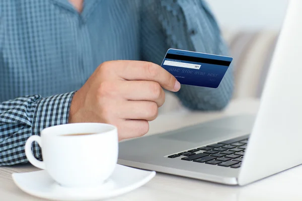 Hombre haciendo compras en línea con tarjeta de crédito en el ordenador portátil — Foto de Stock