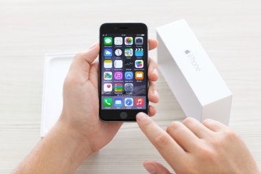 Alushta - 23 Ekim 2014: Masanın üzerinde yeni cep telefonu iPhone 6 Space Gray 'i açan adam. iPhone 6 Apple Inc. tarafından oluşturuldu ve geliştirildi.