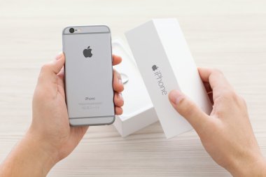 Alushta - 23 Ekim 2014: Masanın üzerinde yeni cep telefonu iPhone 6 Space Gray 'i açan adam. iPhone 6 Apple Inc. tarafından oluşturuldu ve geliştirildi