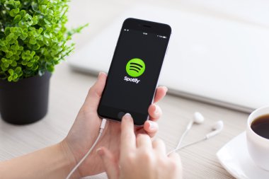 Alushta - 24 Ekim 2014: Ekranda Spotify müzik servisi ile iPhone 6 Space Gray 'i tutan kız. iPhone 6 Apple Inc. tarafından oluşturuldu ve geliştirildi.